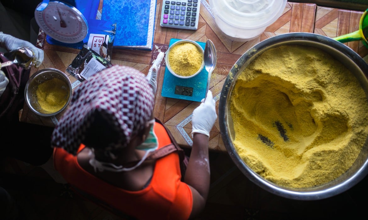 Person measuring bowl of nutritional yeast