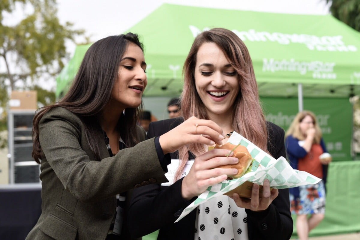 Two people eating plant-based burger