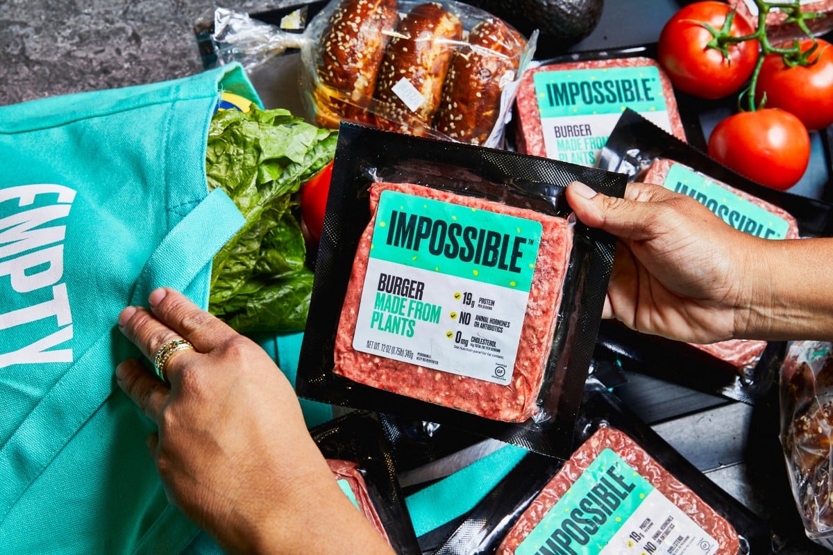 Person putting impossible meat into grocery bag