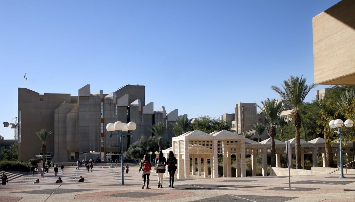 People walking in courtyard with buildings in the background