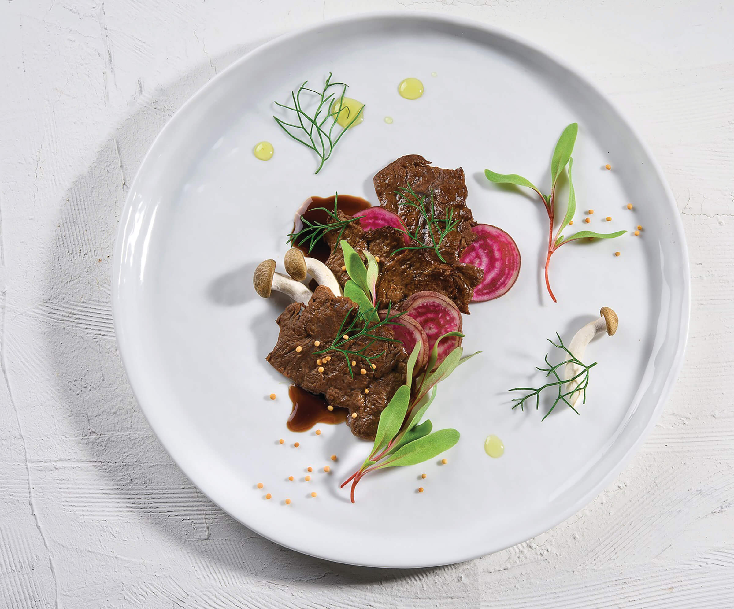 Cultivated meat plated on a white dish