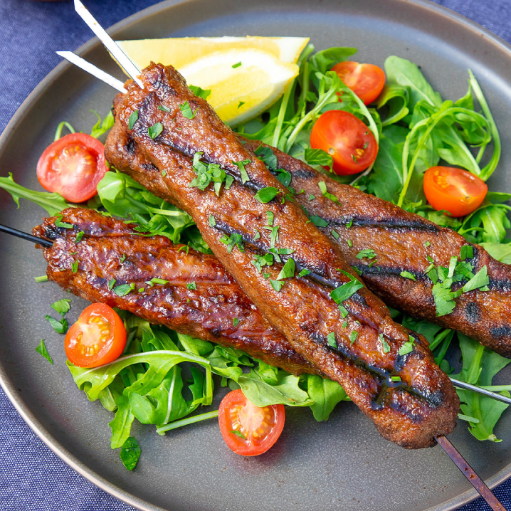 Plant-based retail market overview 8 A plate piled with grilled beyond meat plant-based meditteranean skewers on a bed of greens and grape tomatoes