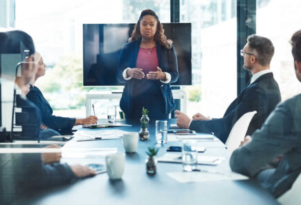 Businesswoman presenting to colleagues in board room