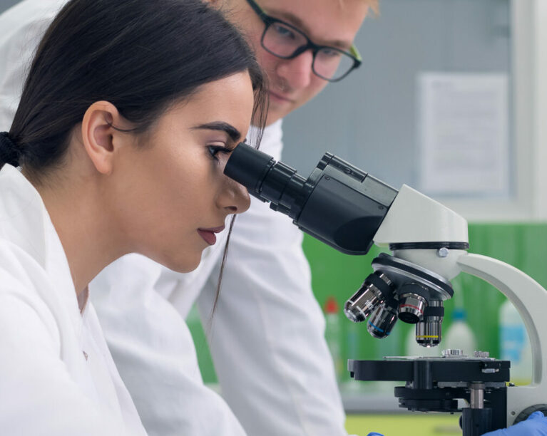 Lab partners looking in microscope