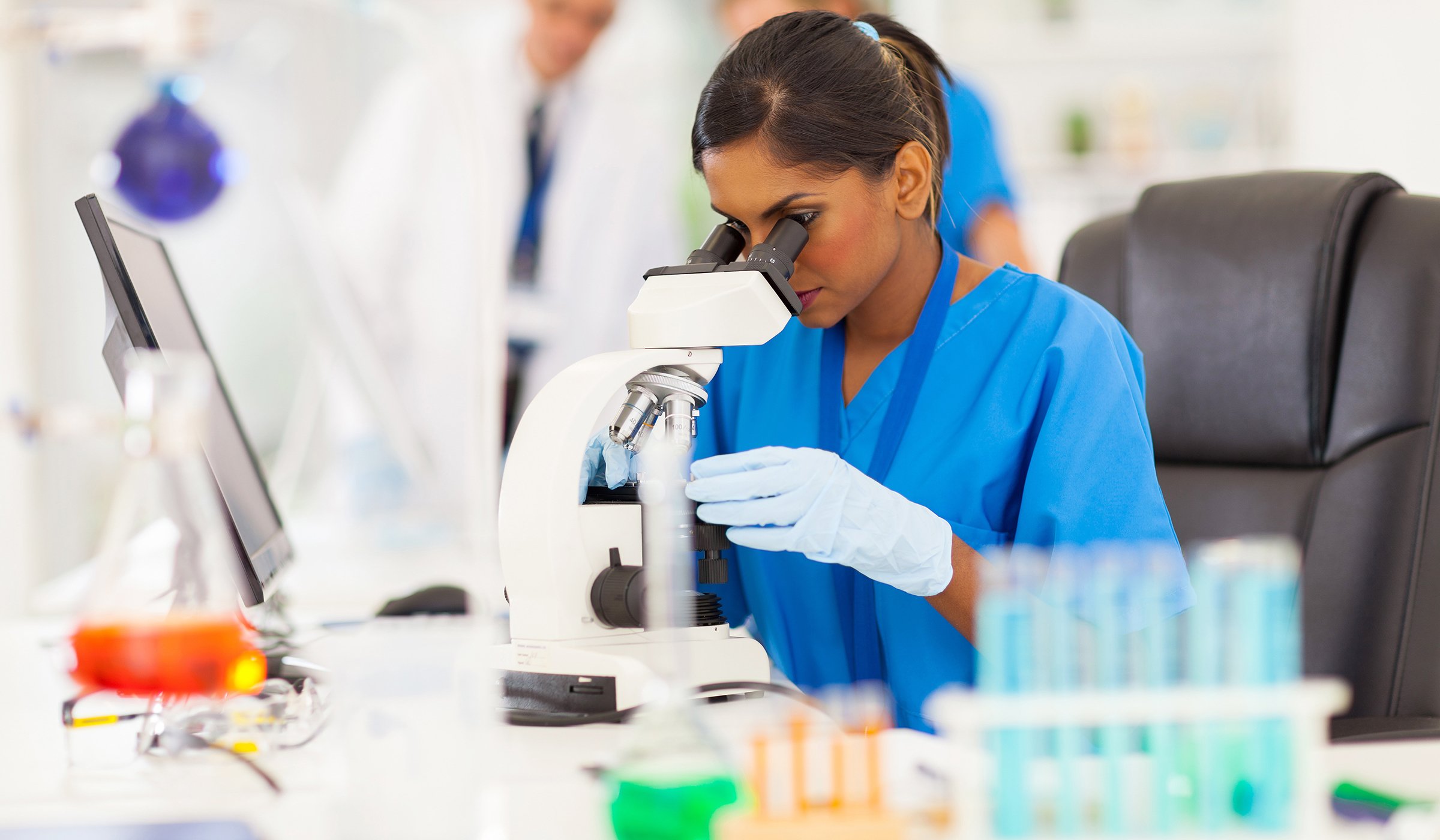 Researcher looking through microscope