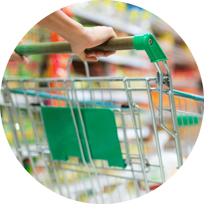 Close up of a grocery cart being pushed down an aisle