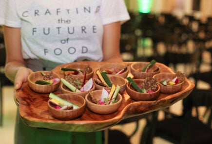 Server holding a tray of appetizers from a GFI Brazil investment event