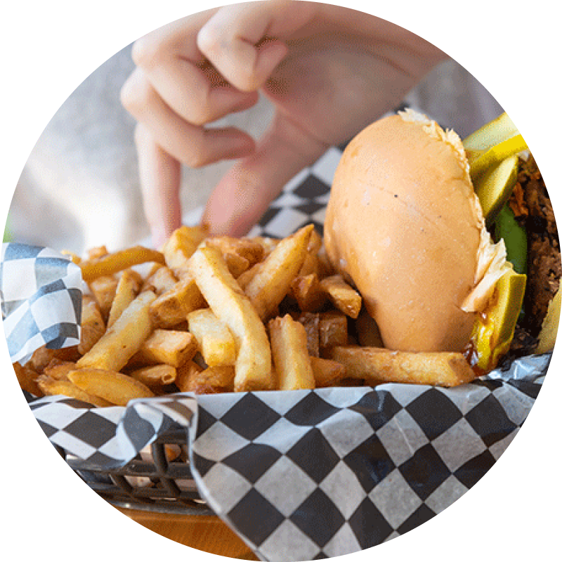 Plant-based burger with fries on checkered paper in a food service context