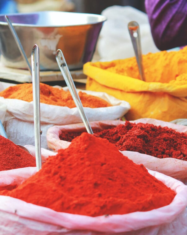 Bulk quantities of several brightly colored spices in bags