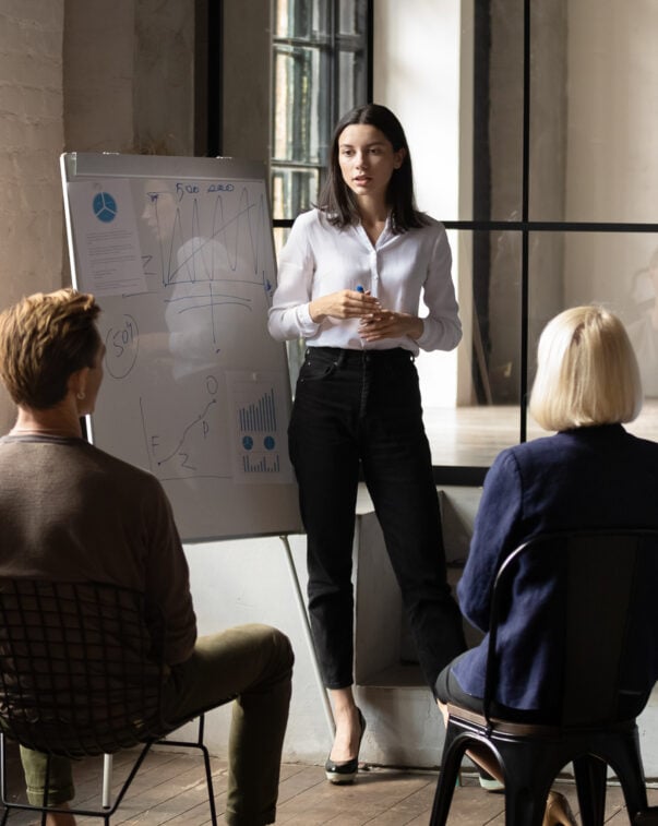 Confident woman presenting to a group of investors in an office conference room