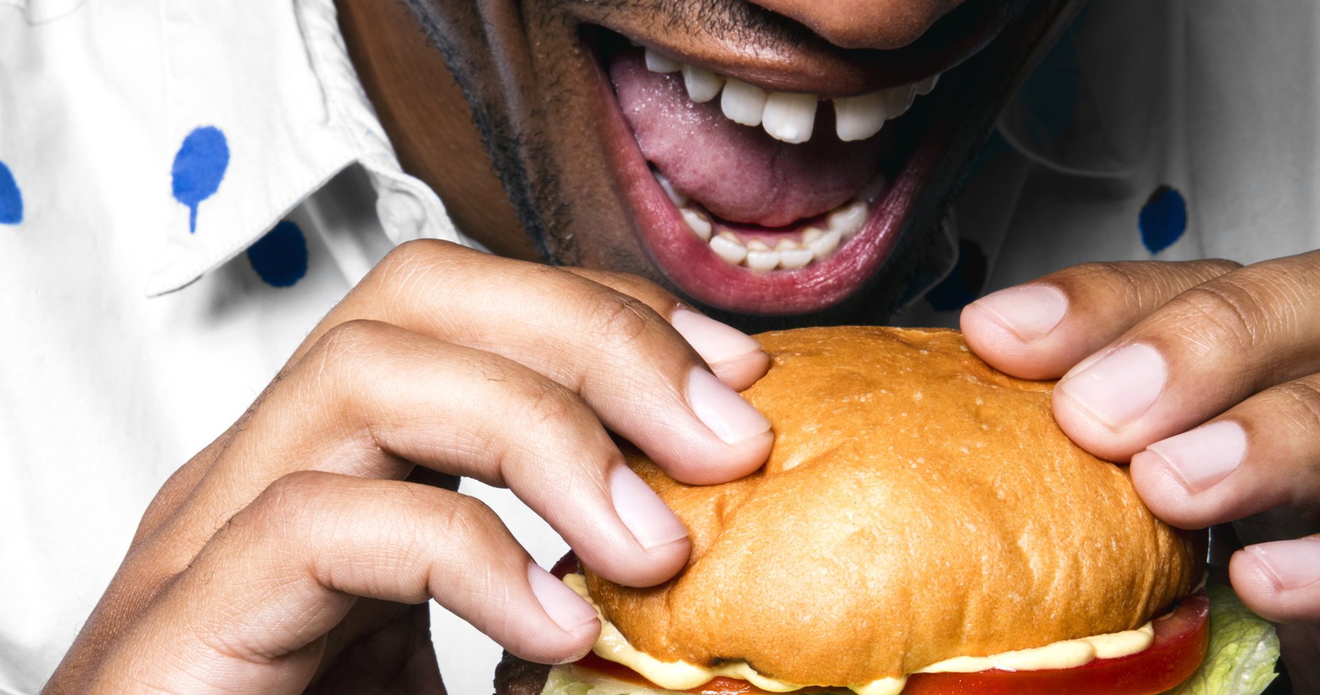 Person taking a bite of a burger