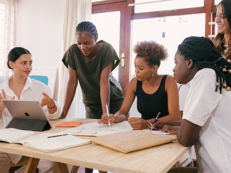 A group of entrepreneurs gathered around a table meeting about their business plan