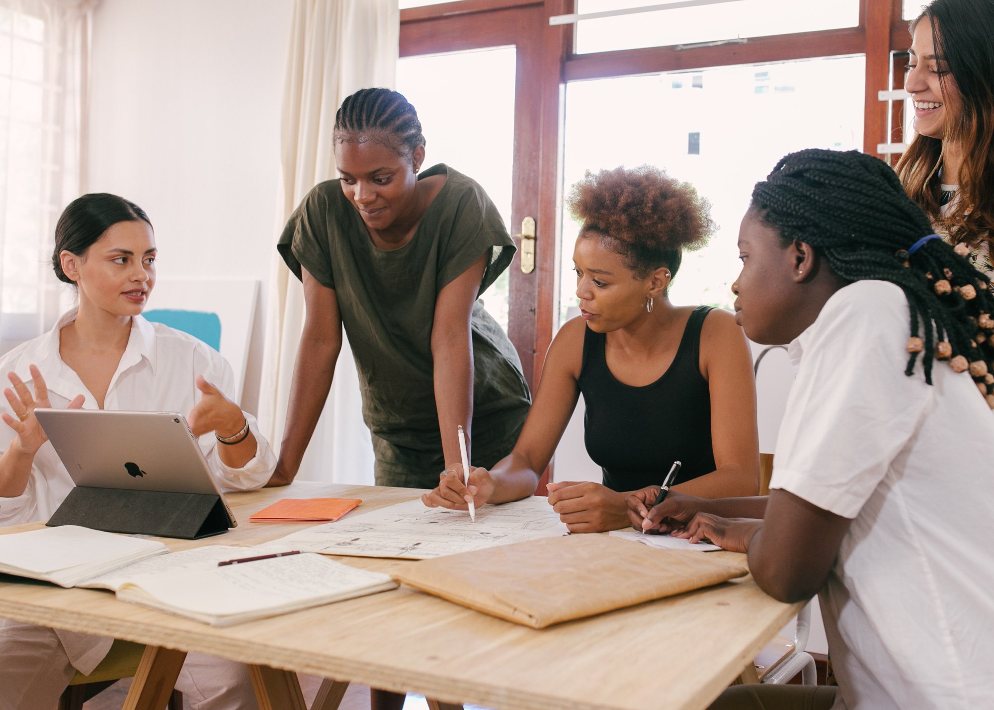 A group of entrepreneurs gathered around a table meeting about their business plan