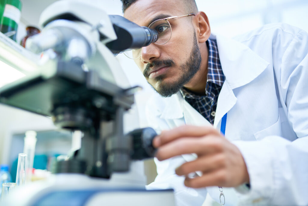 A scientist looking into a microscope