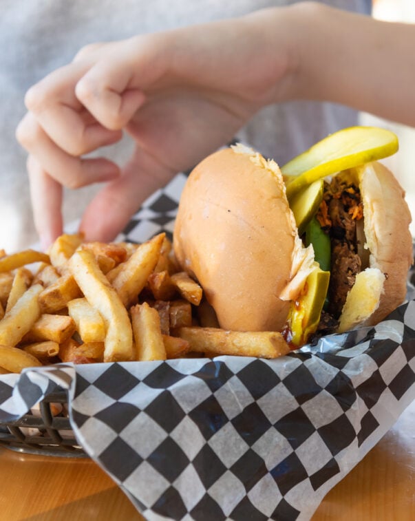 Plant-based burger with fries on checkered paper in a food service context