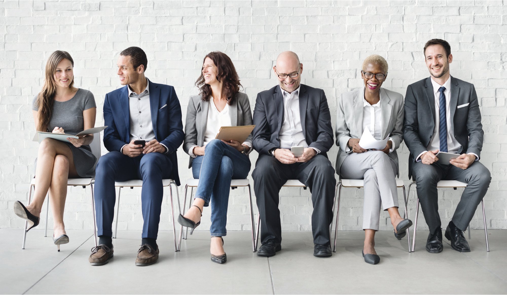 People sitting in chairs in a row, representing a hiring theme