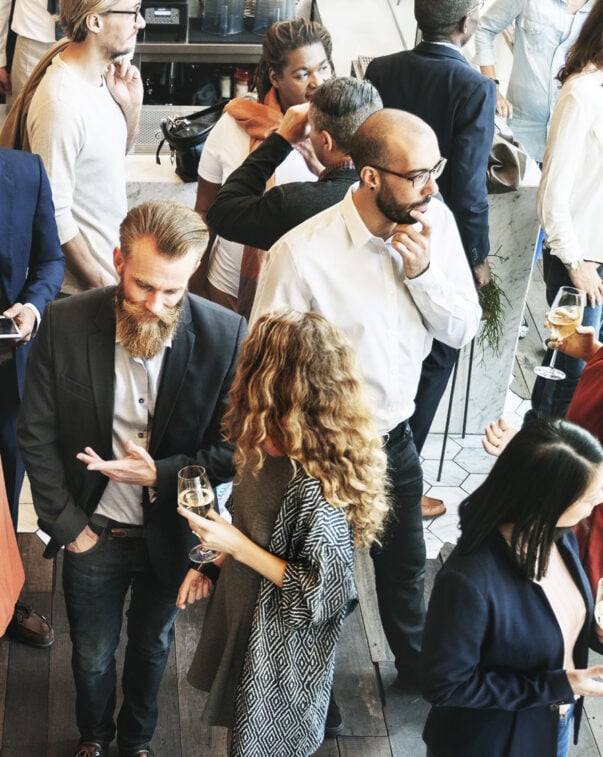 A group of business professionals networking in a brightly lit room