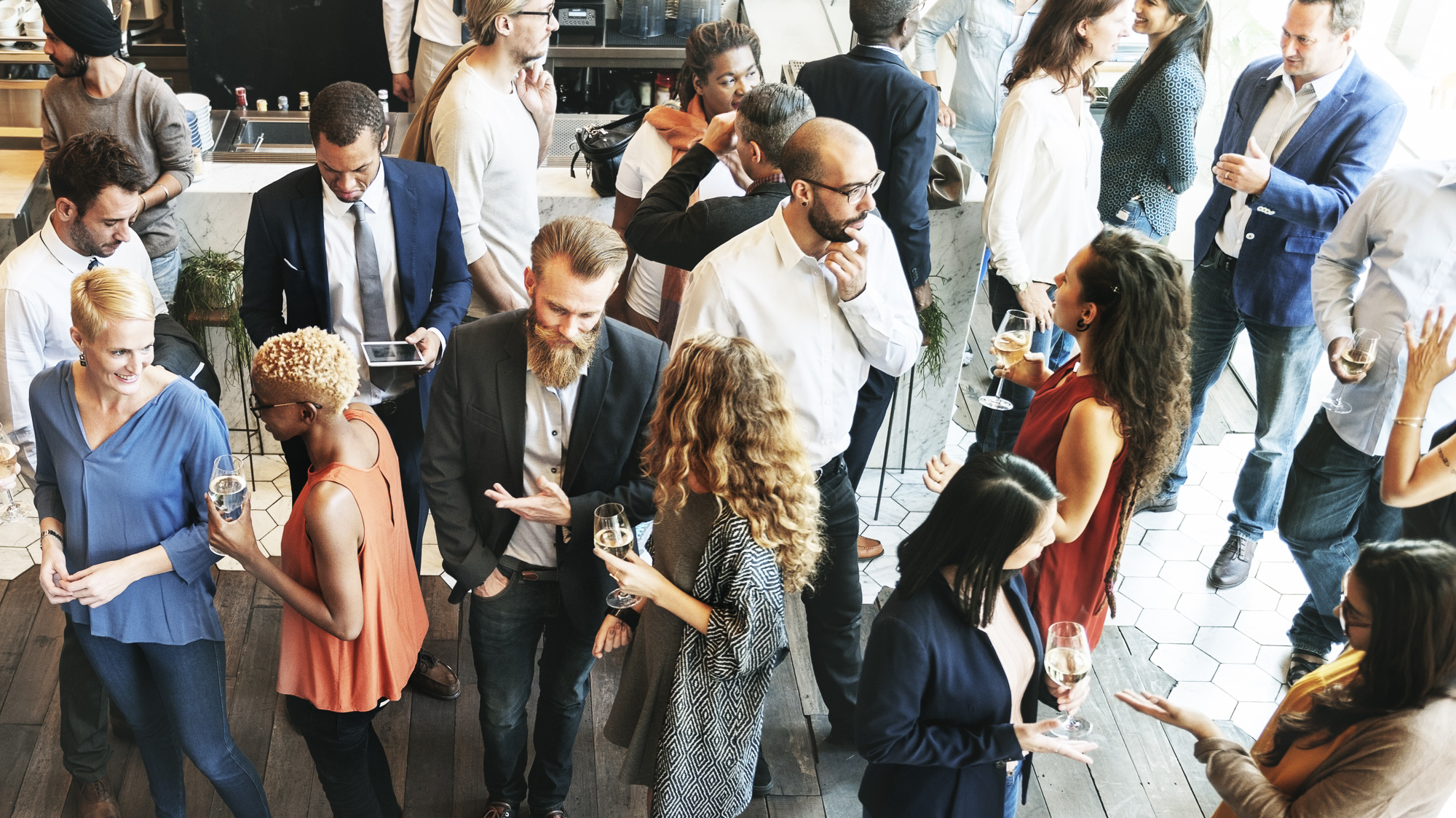 A group of business professionals networking in a brightly lit room