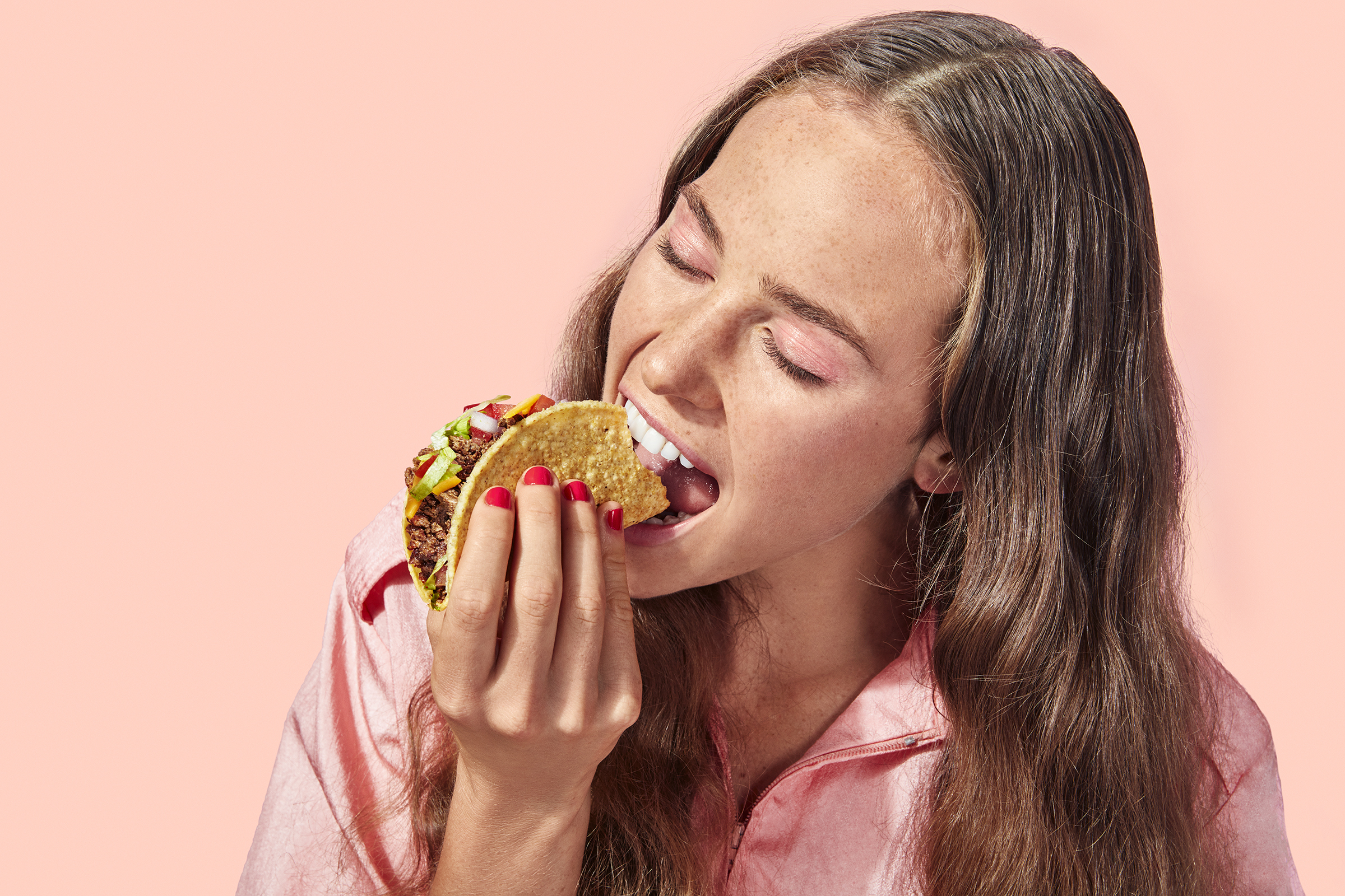 Person taking a bite of a taco