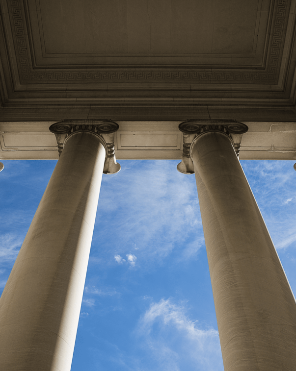 Looking up through legislative building columns at sky