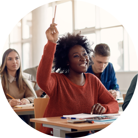 A photo of a student raising their hand in a classroom