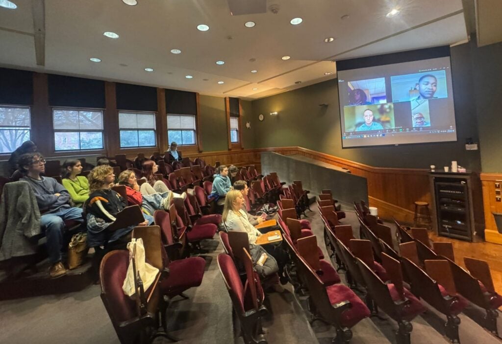 Auditorium of students listening to a virtual presentaiton.