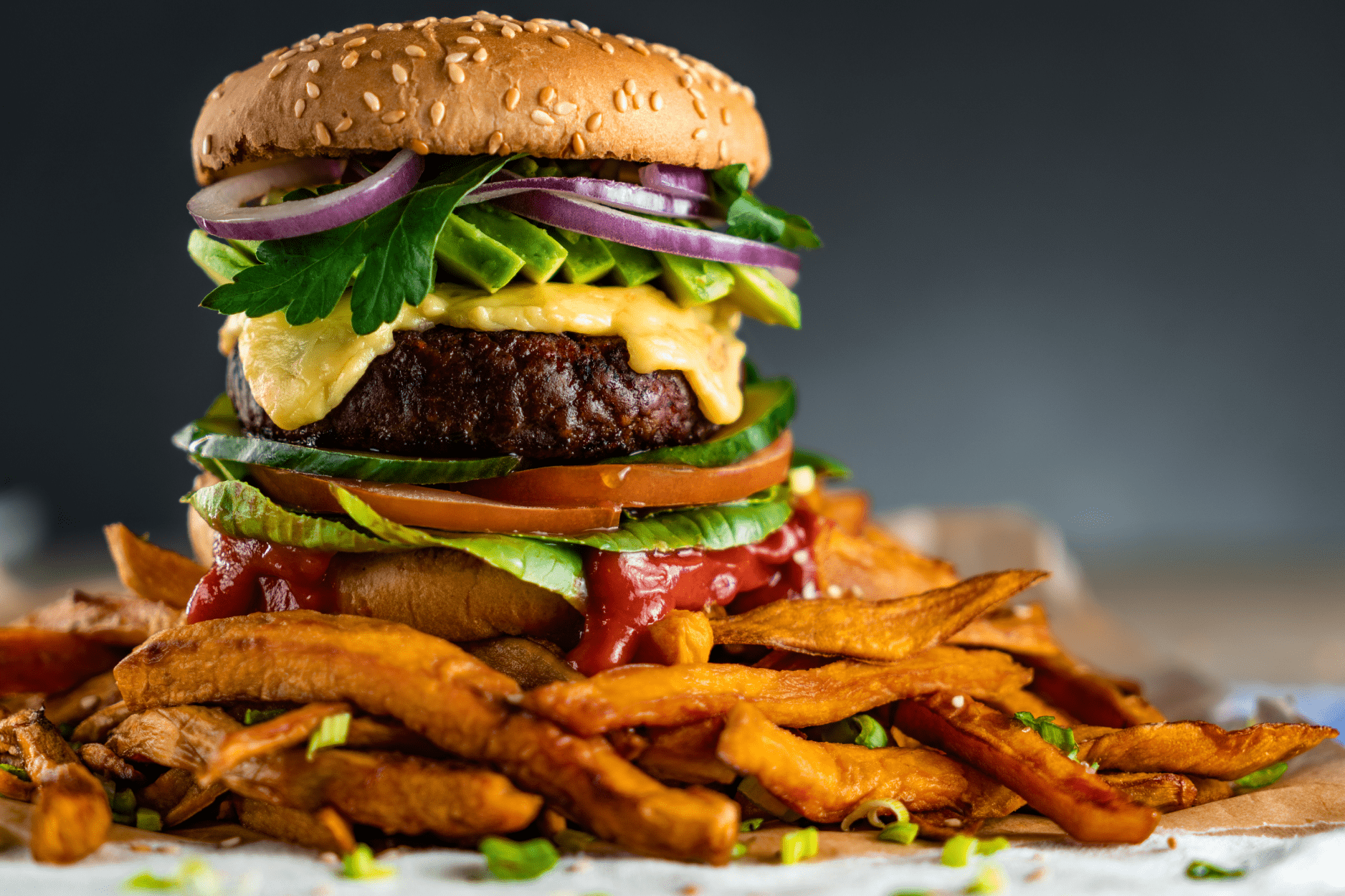 Dressed burger on a mountain of fries