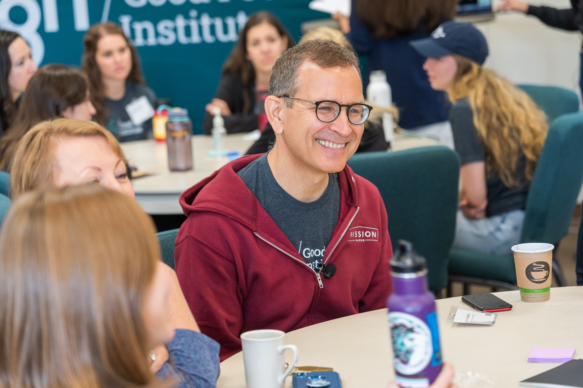 Bruce friedrich smiles at a table during the gfi staff retreat 2022