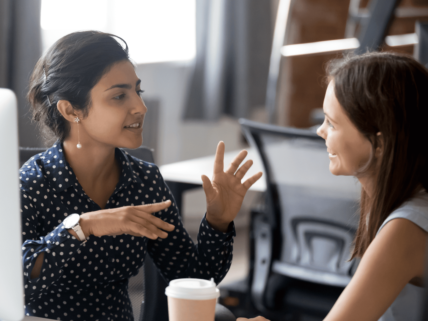 A photo of two entrepreneurs talking together at a desk