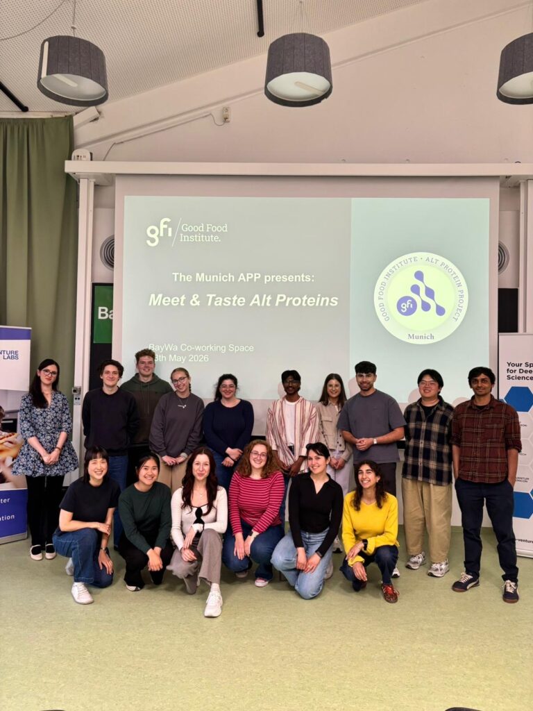 Munich Alt Protein Project executive team and tasting-event participants posing together in front of a presentation screen.