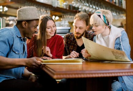 A small group of people reviewing a menu together at a restaurant