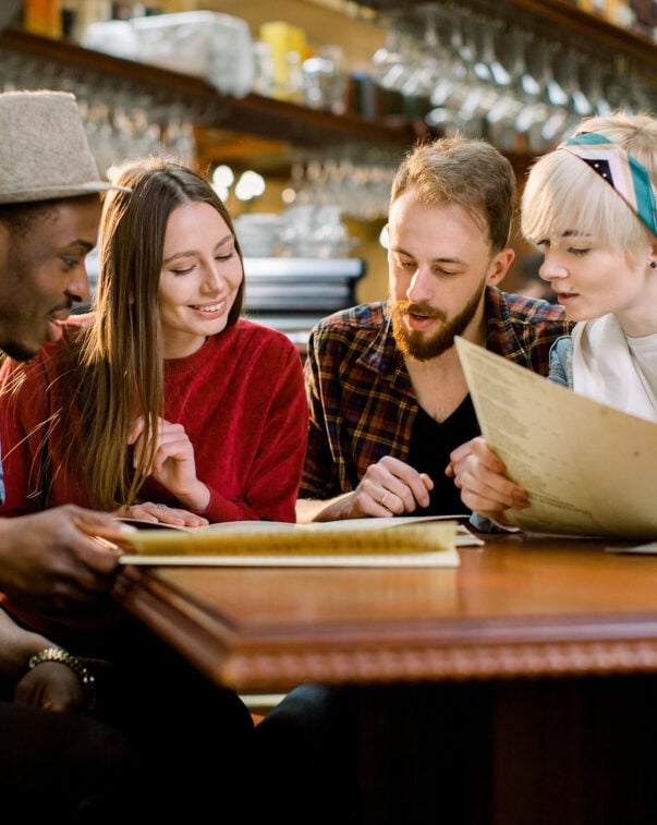 A small group of people reviewing a menu together at a restaurant