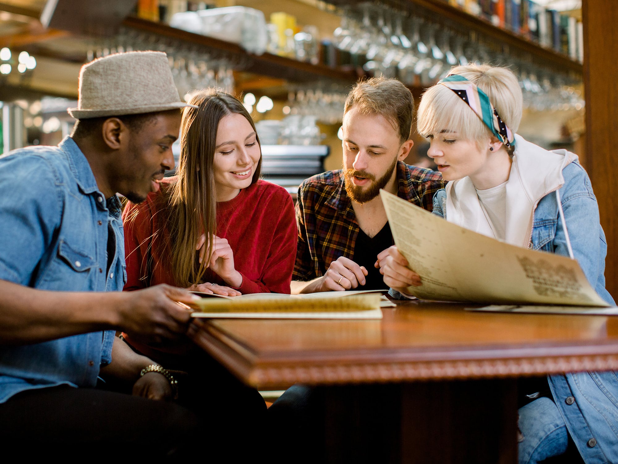 A small group of people reviewing a menu together at a restaurant