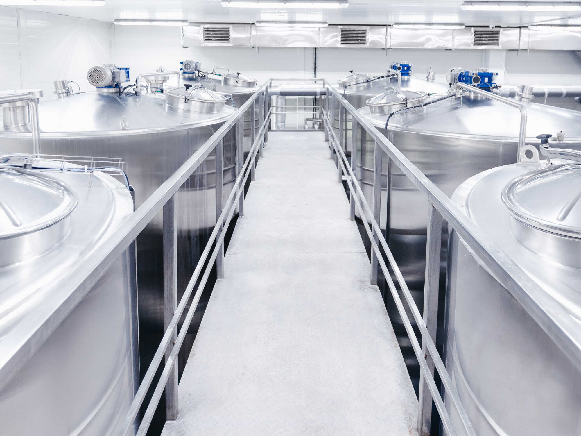 Policy brief: cdmos for food and agriculture biotechnology development 1 A row of large stainless steel industrial fermentation or processing tanks in a clean, modern facility