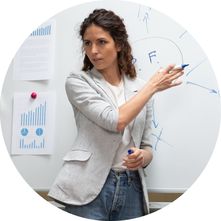 Woman presenting at whiteboard with charts and diagrams