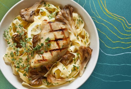Plate of chicken with pasta and mushrooms on ripple background