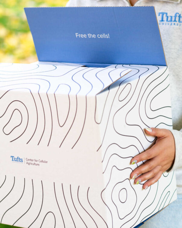 Person holding tufts university cellular agriculture box
