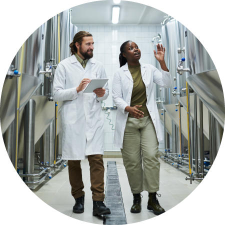 Alternative protein production facilities database 1 Two workers walking between a row of fermentation tanks