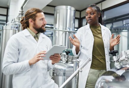 Two workers speaking with each other in a production facility