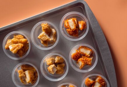 Plant-based chicken pieces in sampling cups on a tray
