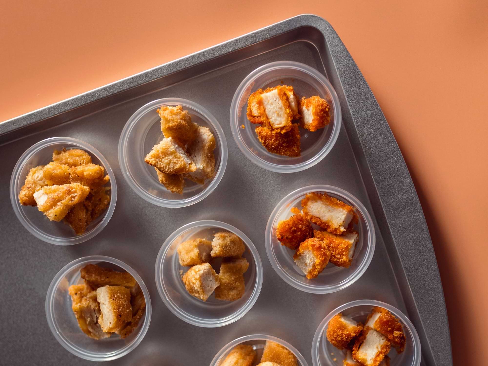 Plant-based chicken pieces in sampling cups on a tray
