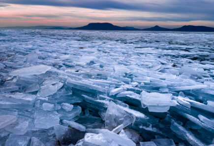 A view of broken up ice with mountains in the distance