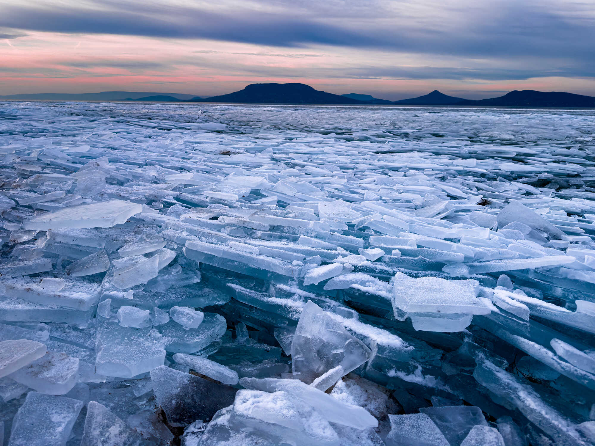 A view of broken up ice with mountains in the distance