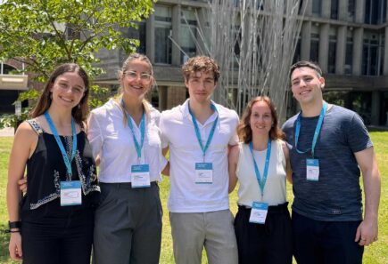 Five college students standing together and smiling at the camera. Photo credit: Inés Macetti.
