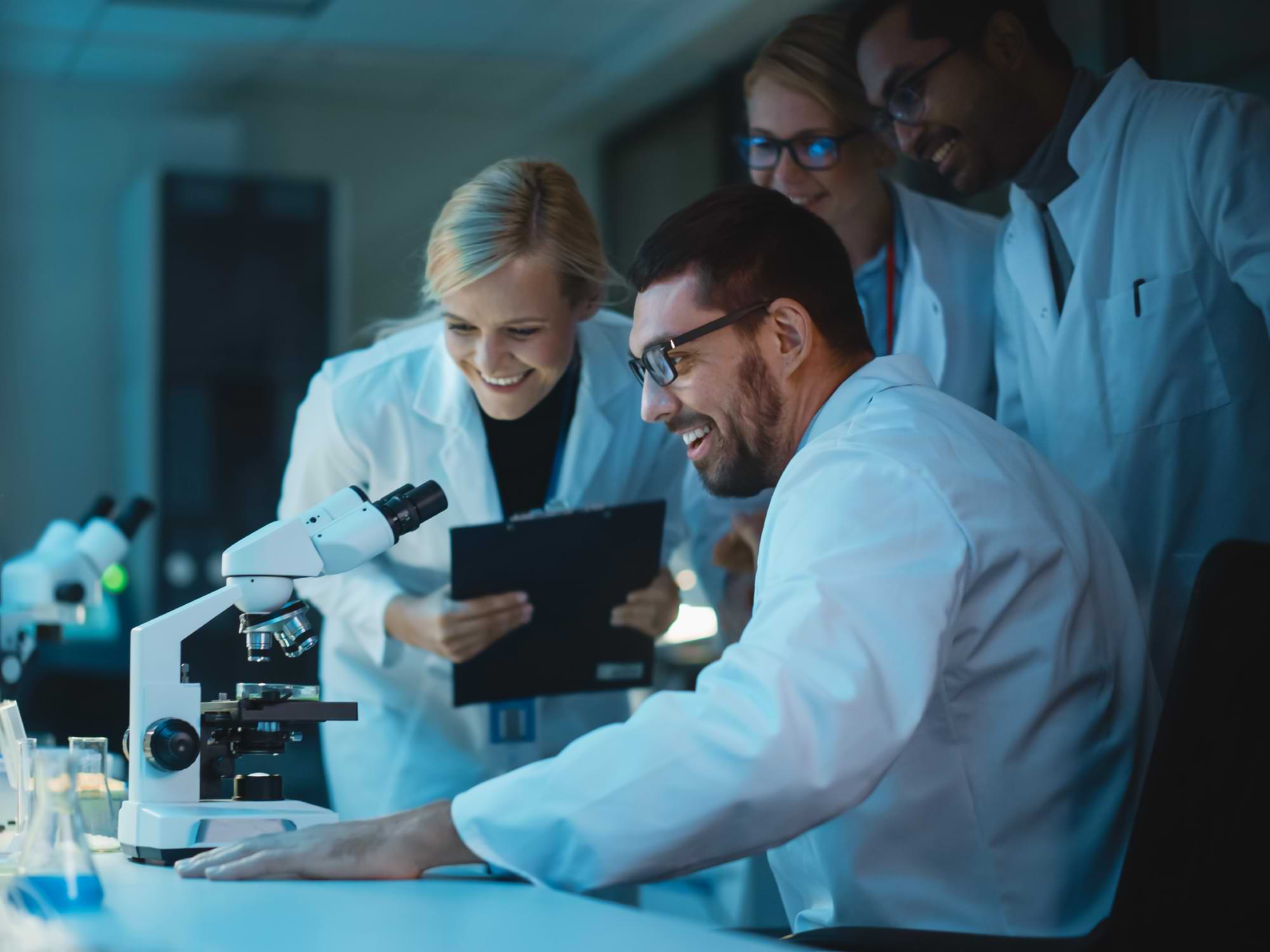 Scientists looking at a microscope in a lab