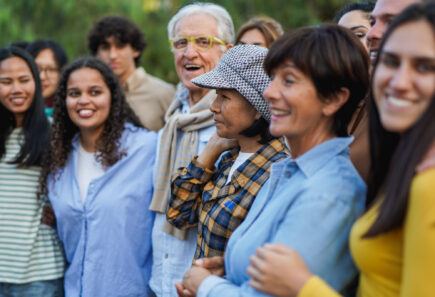Diverse group of people standing in line and smiling