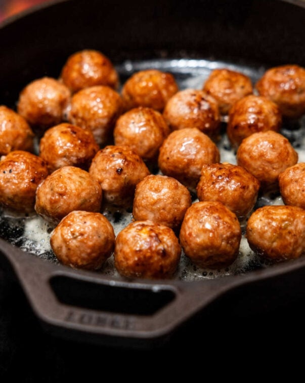 Cultivated pork fat meatballs sizzling on a skillet