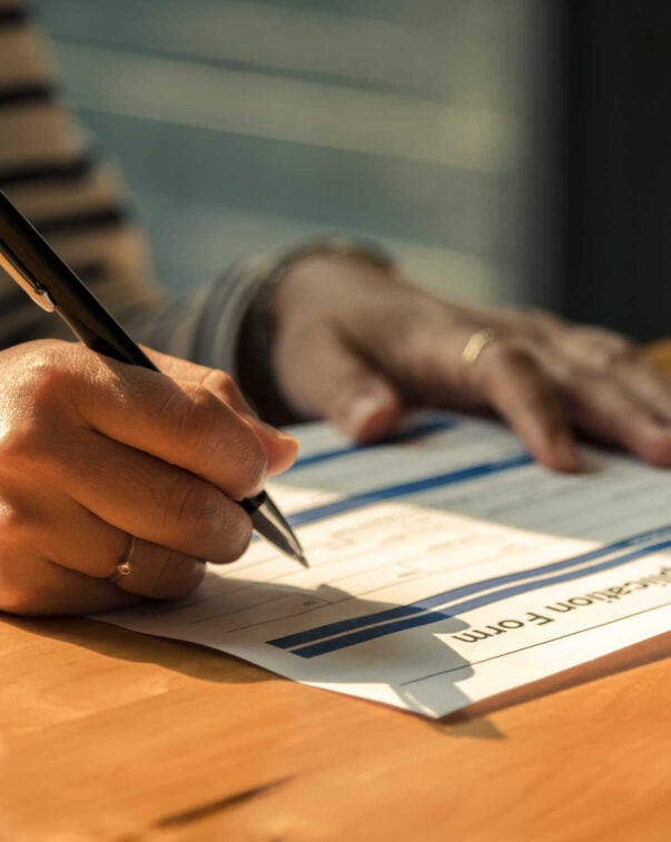A close-up view of a person filling in an application form