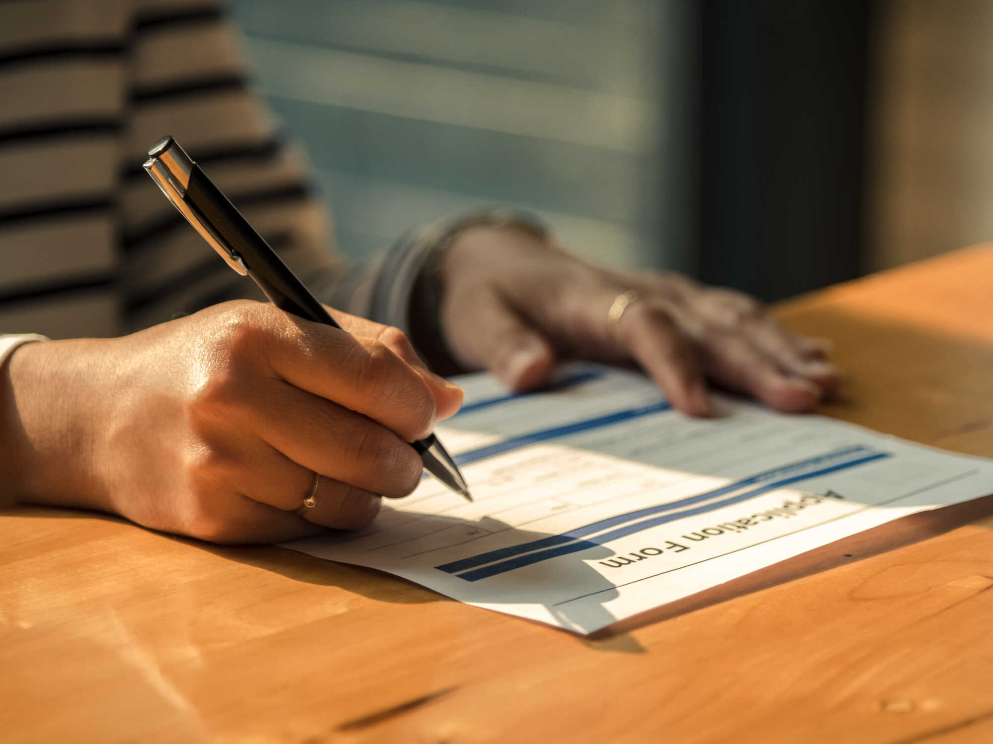 A close-up view of a person filling in an application form