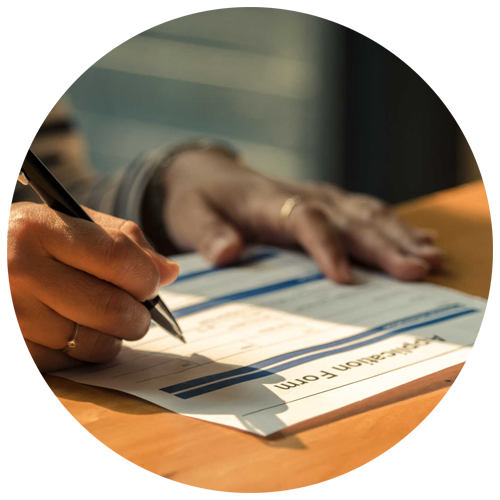 A close up view of a person filling out an application form